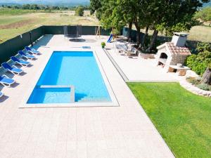 a swimming pool with lounge chairs next to a yard at Holiday Home Villa Maria by Interhome in Donji Proložac