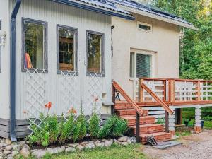a house with a deck and a porch with flowers at Holiday Home Leponiemi by Interhome in Saarijärvi
