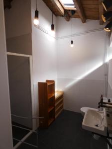 a bathroom with a sink and a toilet and lights at O Albergue in Lugo