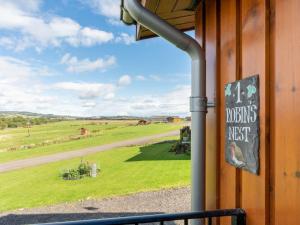 a sign on the side of a building with a view of a field at Chalet Loch Leven Lodge 16- Robin's Nest by Interhome in Kinross