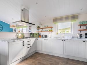 een keuken met witte kasten en een wastafel bij Chalet Loch Leven Lodge 16- Robin's Nest by Interhome in Kinross