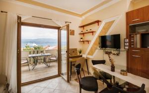 Pokój z balkonem, biurkiem i stołem. w obiekcie Apartman Mediterraneo w mieście Supetar