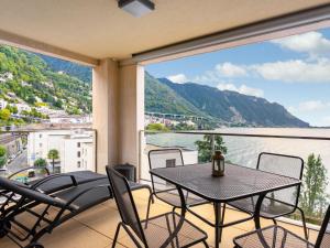 einen Balkon mit einem Tisch und Stühlen sowie Blick auf das Wasser in der Unterkunft Apartment Le Belvédère D2-6 by Interhome in Montreux