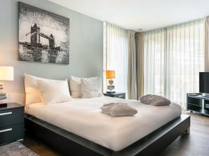 Schlafzimmer mit einem großen weißen Bett und einem großen Fenster in der Unterkunft Apartment Le Belvédère D2-6 by Interhome in Montreux