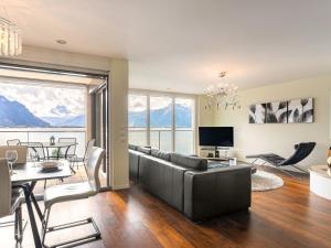 ein Wohnzimmer mit einem Sofa und einem Tisch in der Unterkunft Apartment Le Belvédère D2-6 by Interhome in Montreux