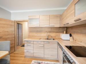 a kitchen with wooden cabinets and a sink at Apartment Poyraz in Bad Gastein