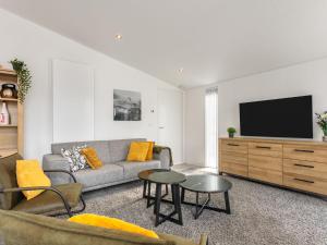 ein Wohnzimmer mit einem Sofa und einem Flachbild-TV in der Unterkunft Holiday Home Vakantiehuis Ruisweg 80 by Interhome in Wemeldinge