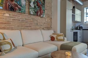 a living room with a couch and a brick wall at CRASH'NSTAY - Casa Barna in Barcelona