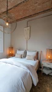 1 dormitorio con 2 camas blancas y 2 lámparas en CRASH'NSTAY - Casa Barna, en Barcelona