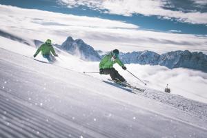 2 personnes font du ski sur une piste enneigée dans l'établissement Apartment Le rose di Marianne - sud, à Varna