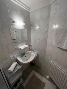 Baño blanco con lavabo y espejo en Ferienwohnung Gertraud und Peter Geisler, en Finkenberg