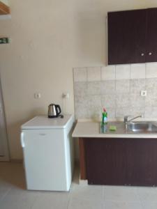 a kitchen with a sink and a refrigerator at Arxontiko Studios in Limenas