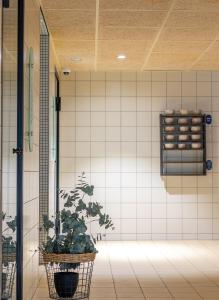 a potted plant in a room with a tile wall at Asa Spa Hotel in Kuressaare