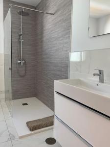 a white bathroom with a shower and a sink at Beautiful Villa Grace, Caleta de Fuste in Caleta De Fuste