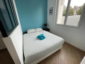- un petit lit avec un ours en peluche bleu dans l'établissement L'avalasse - Petit appartement centre de Rouen - 121, à Rouen