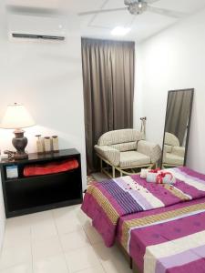 Islamic Homestay Apartment Kundang, Rawang في راوانغ: غرفة نوم بسرير واريكة وكرسي