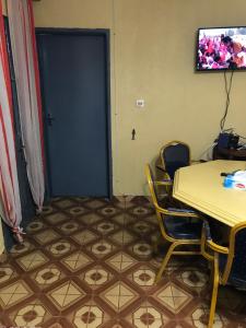 une chambre avec une table, des chaises et une porte bleue dans l'établissement Bel Appartement meublé à Bafoussam, à Bafoussam