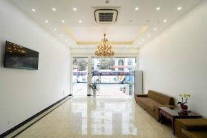 a living room with a couch and a chandelier at Khách sạn Hà Giang Hotel in Ha Long