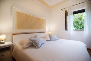 sypialnia z białym łóżkiem i oknem w obiekcie Apartman Mediterraneo w mieście Supetar