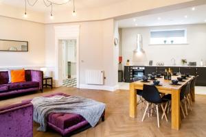 a kitchen and living room with a table and purple furniture at Goodramgate Apartments in York