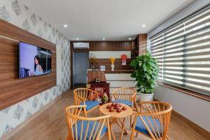 een eetkamer met een tafel en stoelen en een tv bij Coco Homestay in Phu Quoc