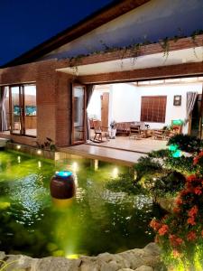 un estanque koi frente a una casa por la noche en Sakura Mura Retreat and Wellness, en Phu Quoc