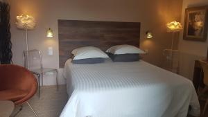 a bedroom with a large white bed with two pillows at La Maison de Charlie in Vaugines