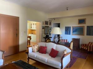 uma sala de estar com um sofá branco com almofadas vermelhas em Traditional And Spacious Apartment In Neo Psychiko em Atenas