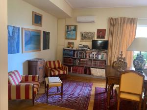 salon z telewizorem, stołem i krzesłami w obiekcie Traditional And Spacious Apartment In Neo Psychiko w Atenach