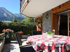 einen Tisch mit einem roten und weißen Tischtuch auf einer Terrasse in der Unterkunft Apartment Ardève 1 by Interhome in Ovronnaz