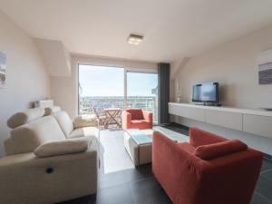 - un salon avec un canapé, des chaises et une télévision dans l'établissement Apartment Skyview with parking by Interhome, à Blankenberge