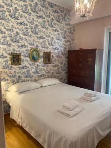 um quarto com uma grande cama branca e papel de parede azul em Traditional And Spacious Apartment In Neo Psychiko em Atenas