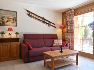 ein Wohnzimmer mit einem roten Sofa und einem Tisch in der Unterkunft Apartment Ardève 1 by Interhome in Ovronnaz