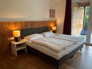 a bedroom with a large bed with two lamps at Apartment Ski & Golf Suites Zell am See by Interhome in Zell am See