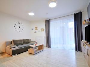 sala de estar con sofá y reloj en la pared en Apartment Szum Morza-5 by Interhome en Kołobrzeg