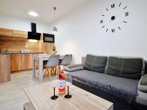 sala de estar con sofá y mesa con copas de vino en Apartment Szum Morza-5 by Interhome en Kołobrzeg