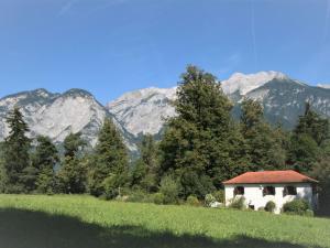 a house in a field with mountains in the background at Holiday Home Vogelhütte by Interhome in Innsbruck