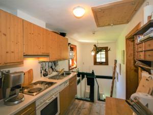 uma cozinha com armários de madeira e um lavatório em Holiday Home Vogelhütte by Interhome em Innsbruck