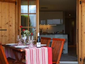 a wooden table with a bottle of wine on it at Apartment Chaperon Rouge A3 by Interhome in Chesières +26 photos