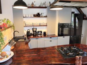 a kitchen with white cabinets and a black refrigerator at Holiday Home Řevnice by Interhome in Řevnice