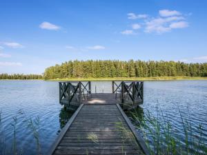 a wooden dock in the middle of a lake at Holiday Home Villa blombacka by Interhome in Isnäs +15 photos