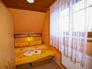 a small bedroom with a yellow bed and a window at Apartment Rieger 3 by Interhome in Harrachov