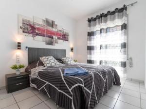 ein Schlafzimmer mit einem Bett mit einer gestreiften Decke in der Unterkunft Holiday Home Flamenco by Interhome in Empuriabrava