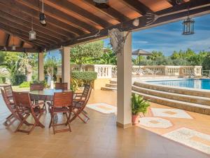 a patio with a table and chairs and a pool at Villa Ca na Fideu by Interhome in Alcudia