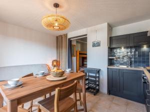 uma cozinha e sala de jantar com uma mesa de madeira e cadeiras em Apartment Ortal Océan-9 by Interhome em Lacanau-Océan