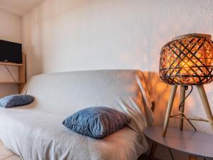 um quarto com um sofá com um candeeiro sobre uma mesa em Apartment Ortal Océan-9 by Interhome em Lacanau-Océan