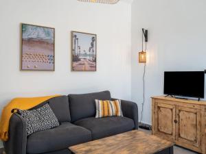 a living room with a couch and a flat screen tv at Apartment Le Clos Moguer-2 by Interhome in Quiberon