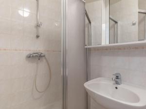 a white bathroom with a shower and a sink at Apartment Les Lauzes-7 by Interhome in Les Menuires