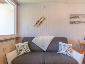 a couch with pillows on it in a room at Apartment Les Lauzes-7 by Interhome in Les Menuires