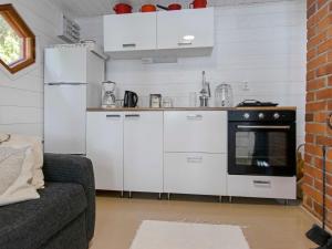 a kitchen with white cabinets and a black oven at Holiday Home Villa kesäranta by Interhome in Muurame